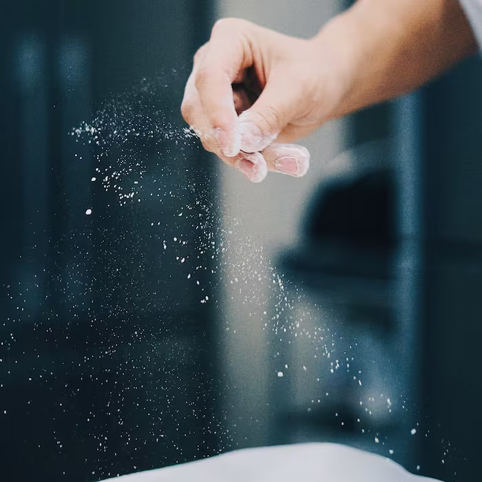 Chef adding garlic powder to the food while cooking